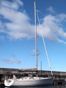 a sailboat sitting in the water next to a bridge at Timeresci in Calheta