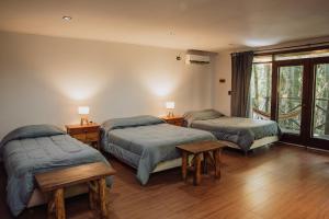 a bedroom with two beds and two tables and a window at Tierra Guaraní Lodge in Puerto Iguazú +77 photos