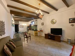 ein Wohnzimmer mit Sofa und Fernseher in der Unterkunft Casa Francesco in Forza dʼAgro