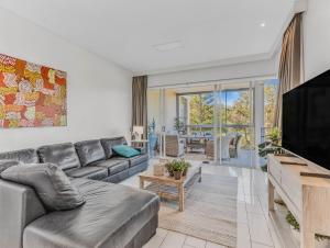 a living room with a couch and a flat screen tv at Bali Luxury Resort - Holiday Management in Kingscliff