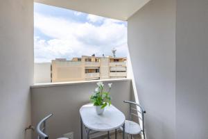 a small white table and chairs on a balcony with a window at Stanza idromassaggio 2 in Quartu SantʼElena
