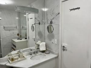 a bathroom with a sink and a mirror at Center Suiço Flats in Campos do Jordão +290 photos
