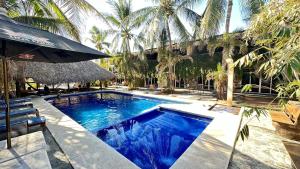 a swimming pool in a resort with palm trees at Arca in Brisas de Zicatela