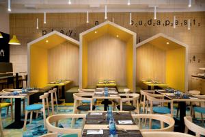 um restaurante com mesas e cadeiras num quarto em Ibis Styles Budapest Center em Budapeste