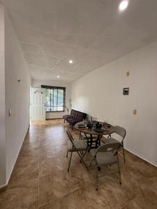 een woonkamer met een tafel, stoelen en een bank bij Casa Naay in Cancun