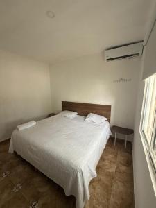 een slaapkamer met een wit bed en een raam bij Casa Naay in Cancun