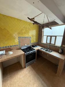 een keuken met een fornuis en een spoelbak bij Casa Naay in Cancun