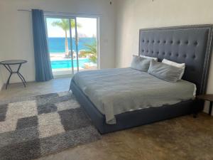 a bedroom with a bed with a view of the ocean at Casa Termales Solo Adultos Frente al Mar Sistema Solar in El Sargento