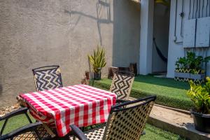 a table and two chairs with a red and white checkered table cloth at Hotel Family House Rodadero in Santa Marta