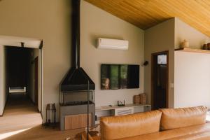 a living room with a couch and a stove at Elegante bangalô de campo 1- Taquaras Huts in Rancho Queimado
