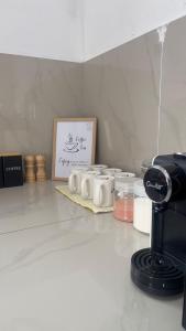 a kitchen with a counter with coffee cups on a table at Villa Alyana in Ipoh