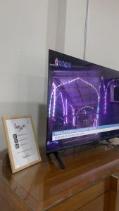 a tv sitting on a table next to a sign at Villa Alyana in Ipoh