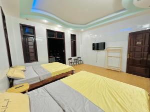 a room with two beds and a flat screen tv at Cali homestay in Phú Vang