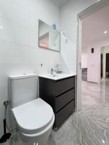 a white bathroom with a toilet and a sink at Spacious 3-bdr apartment - Palmarejo Grande - LCGR in Praia
