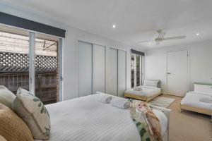 una camera da letto con un letto grande e un divano di Lazy Days in Lennox a Lennox Head Altre 29 foto