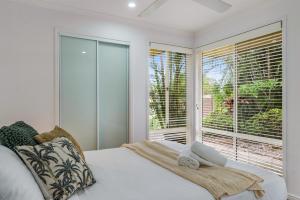 una camera da letto con un letto e una grande finestra di Lazy Days in Lennox a Lennox Head