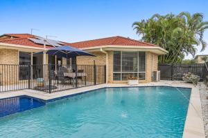 una piscina davanti a una casa di Lazy Days in Lennox a Lennox Head