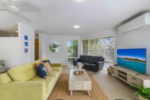 un soggiorno con divano giallo e TV di Lazy Days in Lennox a Lennox Head