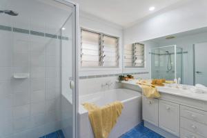 bagno bianco con vasca e doccia di Lazy Days in Lennox a Lennox Head
