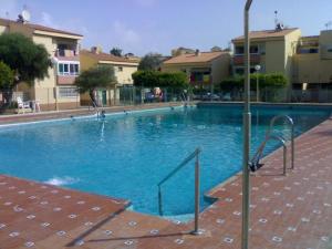 a swimming pool with blue water in front of some buildings at Costa Serena apartment 1ª línea in Roquetas de Mar