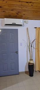 a blue door and a vase with a plant next to it at El Rincón del Viajero A&A in Santa Rosa