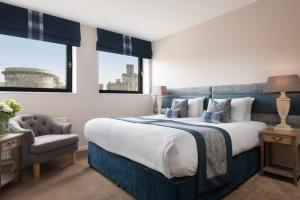 a hotel room with a large bed and a large window at Princes Street Suites in Edinburgh