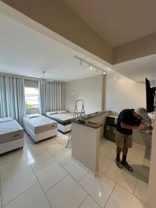 アハイアウ・ド・カボにあるArraial Hospedagemの部屋の台所に立つ男