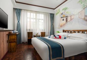 a hotel room with a large bed and a tv at Nostalgia Hotel Beijing Yonghe Lama Temple in Beijing