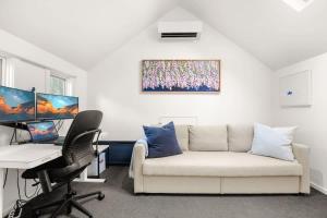 - un salon avec un canapé et un bureau avec un ordinateur dans l'établissement 'Chateau York' - Relaxed Prahran Family Home, à Melbourne