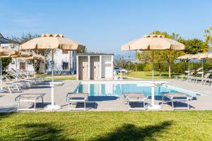 AlbanellaにあるVilla Hera Relaxのパラソルと椅子付きのスイミングプール、スイミングプールバイザー