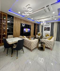 salon z kanapami, stołem i telewizorem w obiekcie King C w mieście Lekki