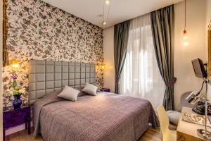 a bedroom with a bed and a floral wall at Parlamento Boutique Hotel in Rome