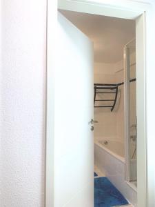 a bathroom with a white door and a bath tub at Kompakt & Ruhig - Nähe Hannover Messe in Hannover +5 photos