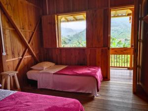 a room with two beds and a window at Cabañas Villa Juliana in Jardin