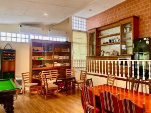 a dining room with a table and a pool table at Country Lake View Hotel in Suphan Buri