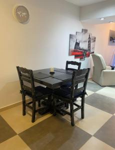 a black dining room table with two chairs and a couch at Apart Duclout Monte Grande a 15 minutos del Aeropuerto EZE in Monte Grande +1 photo