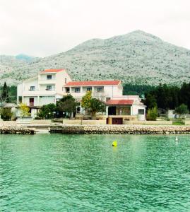 una casa en la orilla de un cuerpo de agua en Bed and Breakfast MIRAMAR, en Starigrad-Paklenica