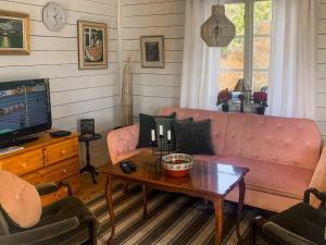 a living room with a pink couch and a table at 3 person holiday home in ÖDSMÅL in Ödsmål