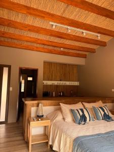 a bedroom with a large bed with a wooden ceiling at Elegante Cabaña en Purmamarca in Purmamarca