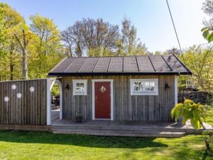 a tiny house with a red door and a deck at 4 star holiday home in Drottningskär in Drottningskär +19 photos