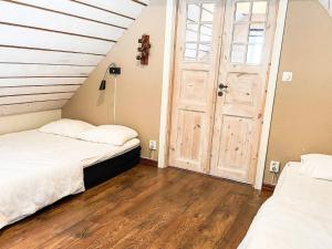 two beds in a room with a wooden door at 4 star holiday home in Drottningskär in Drottningskär