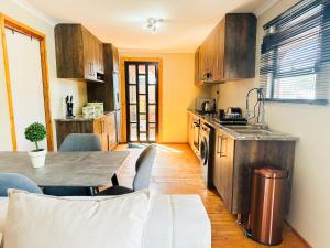 a kitchen with wooden cabinets and a table with chairs at The Man Cave in Sabie