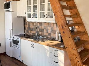a kitchen with white cabinets and a wooden ladder at 4 star holiday home in Drottningskär in Drottningskär