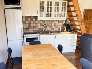 a kitchen with white cabinets and a wooden table at 4 star holiday home in Drottningskär in Drottningskär +30 photos