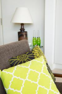 eine Couch mit einem Kissen und einer Lampe auf einem Tisch in der Unterkunft City lights, Jewel in the Crown, Waiheke Island in Waiheke Island