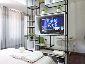 Cette chambre dispose d'une télévision et d'un lit avec des draps blancs. dans l'établissement Estudio de Lujo, Cerca de la Plaza, à Tarija