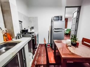 une cuisine avec un réfrigérateur en acier inoxydable et une table dans l'établissement Estudio de Lujo, Cerca de la Plaza, à Tarija 19 autres photos