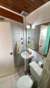 a bathroom with a sink and a toilet and a mirror at Hostal Boutique F in El Quisco +146 photos