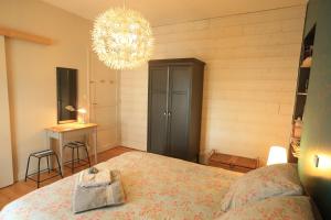 Un dormitorio con una cama grande y una lámpara de araña. en Chambre d'Hôte à Douarnenez en Douarnenez