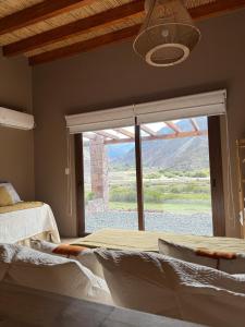 a bedroom with a large window with a view at Distinguida Cabaña en Purmamarca in Purmamarca